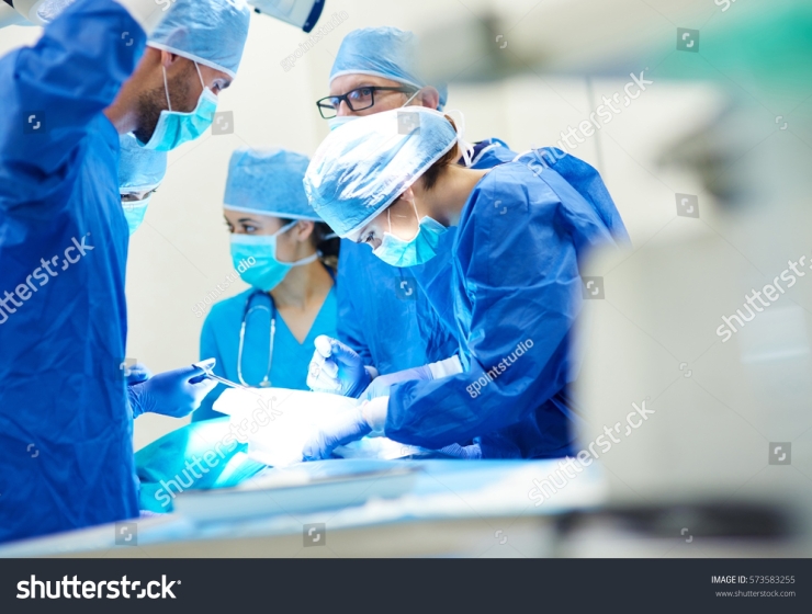 Stock photo close up of surgery team operating 573583255